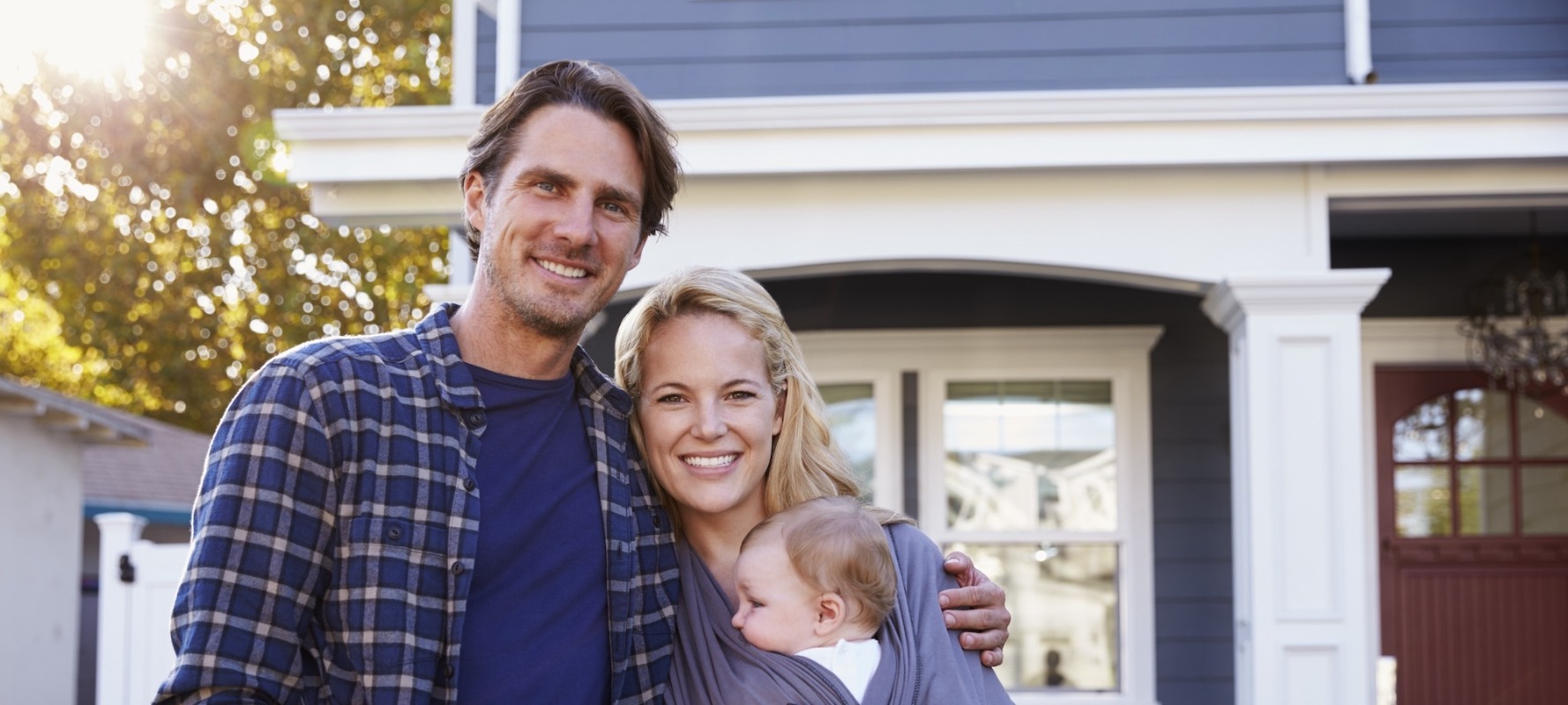 happy family standing in front of home